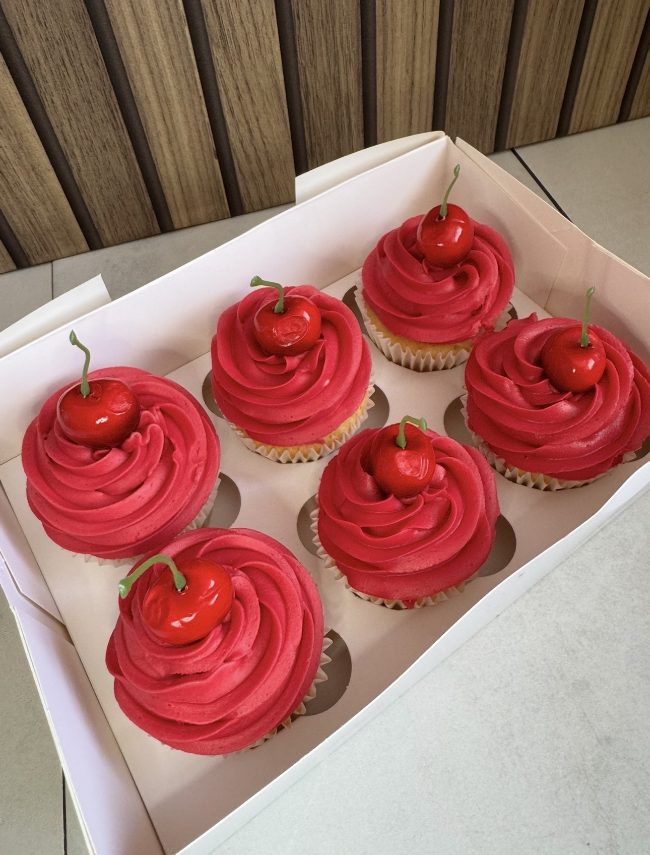 Cherry-topped red buttercream cupcakes
